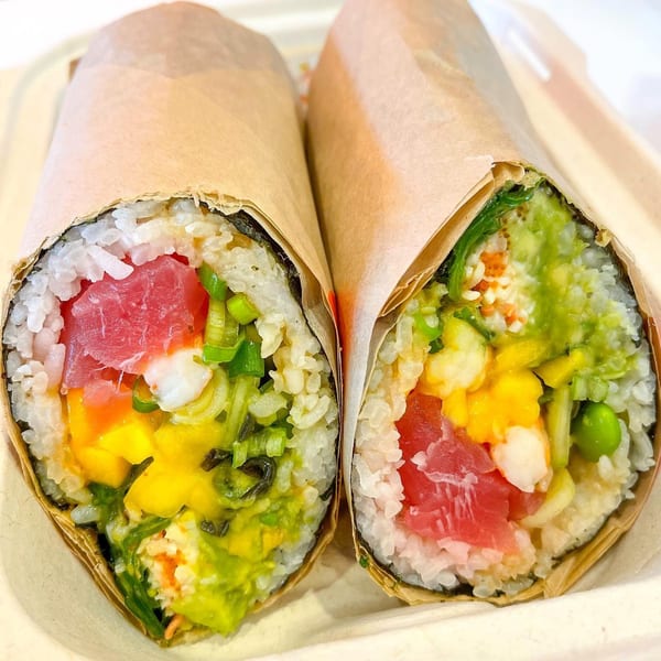 Two Yo Poké Fusion burritos, one with tuna, mango, and avocado, the other with various fresh ingredients.