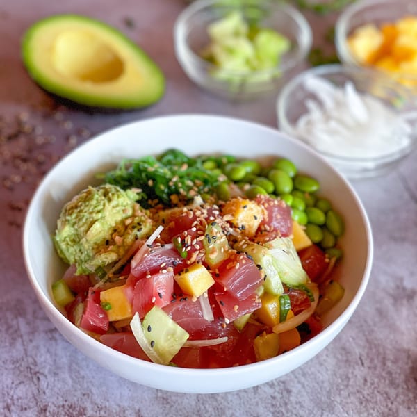 A vibrant Yo Poké Fusion bowl with tuna, avocado, edamame, and seaweed salad.